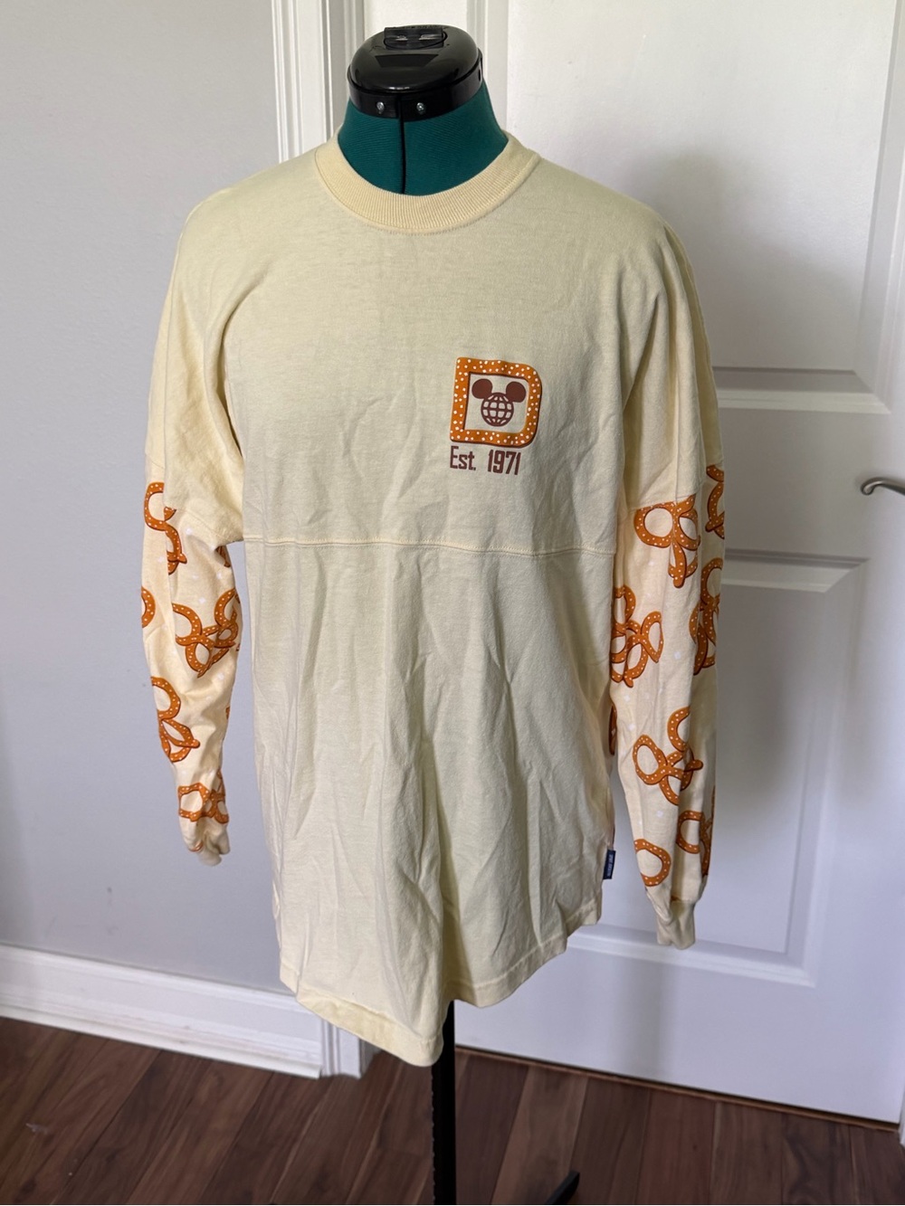 Disney Cream Long Sleeve Tee with Orange Pretzel Sleeve Graphics